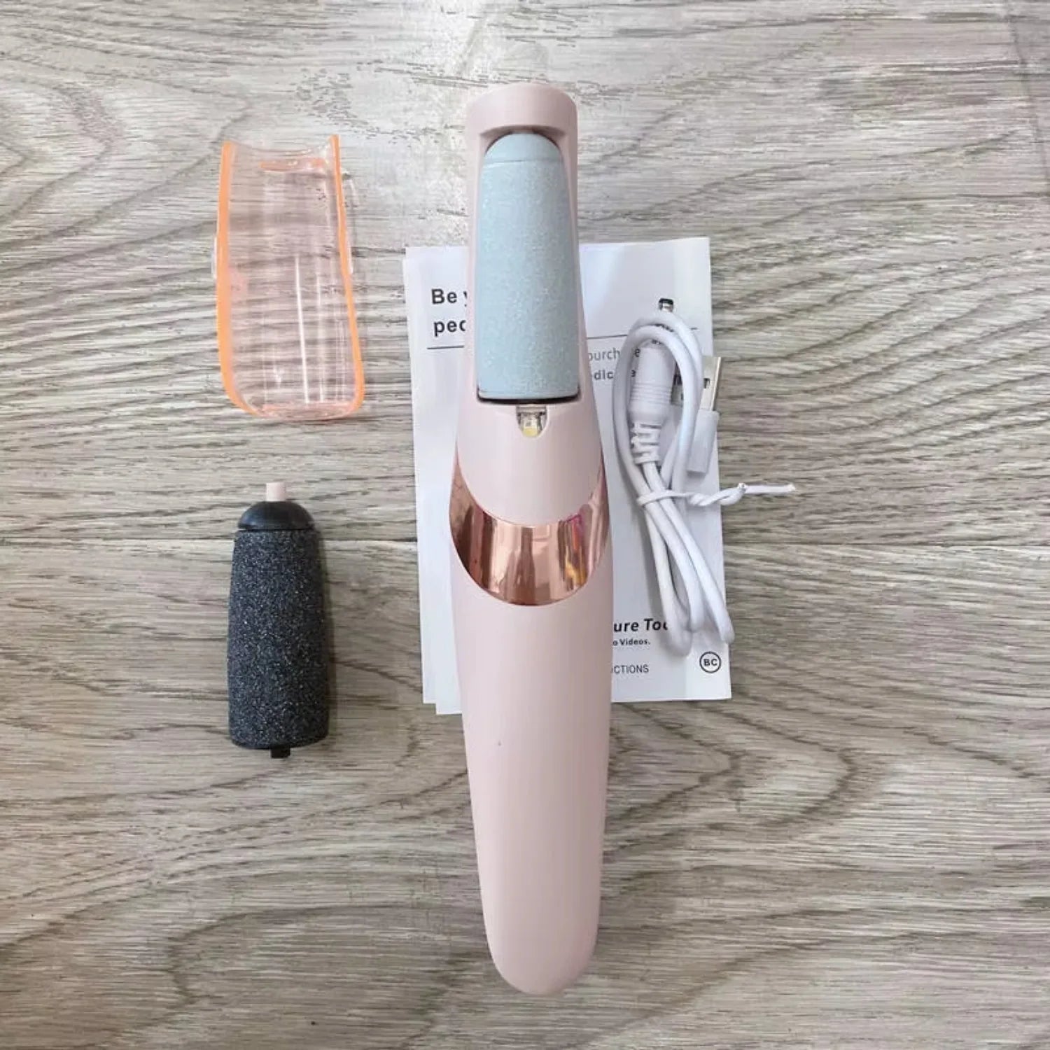 Beauty tool with attachments and packaging on a wooden surface