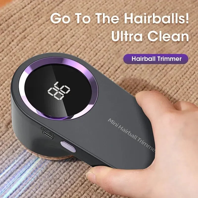 Electric lint remover with digital display and fabric shaver head with digital display held by a hand on a textured surface